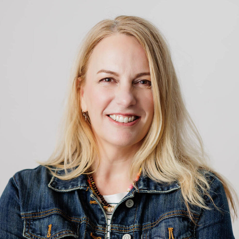 blond woman smiling with arms crossed